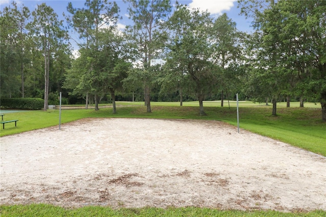 surrounding community featuring volleyball court and a lawn