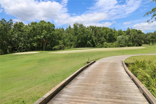 view of community featuring golf course view and a yard