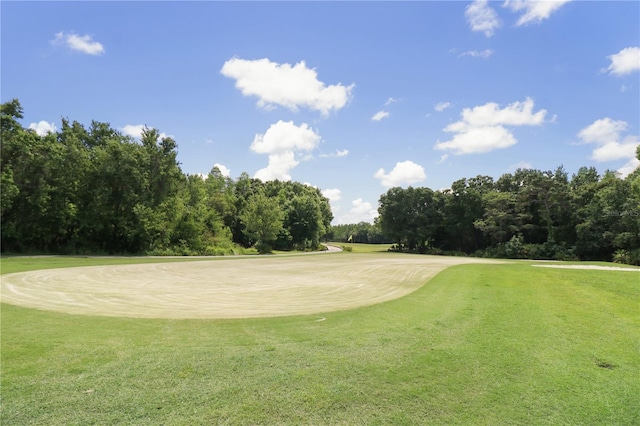 surrounding community with view of golf course and a lawn