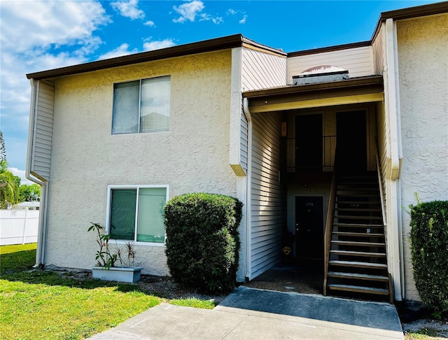 view of front facade featuring a front yard, fence, and stucco siding