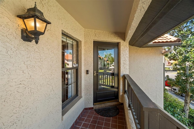 doorway to property featuring a tiled roof and stucco siding