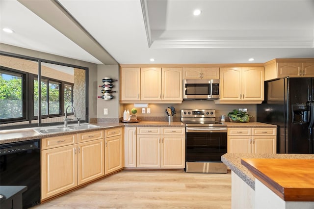 kitchen featuring recessed lighting, light brown cabinets, a sink, light wood-type flooring, and black appliances