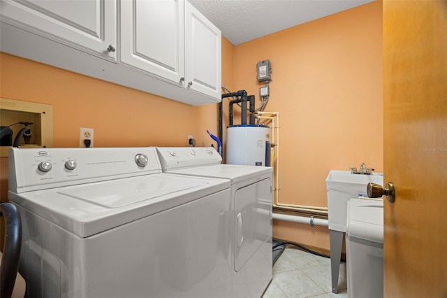 laundry area with cabinet space, washer and clothes dryer, a textured ceiling, water heater, and light tile patterned flooring