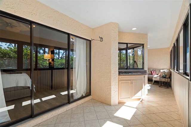 doorway to outside with light tile patterned floors, recessed lighting, and a textured wall