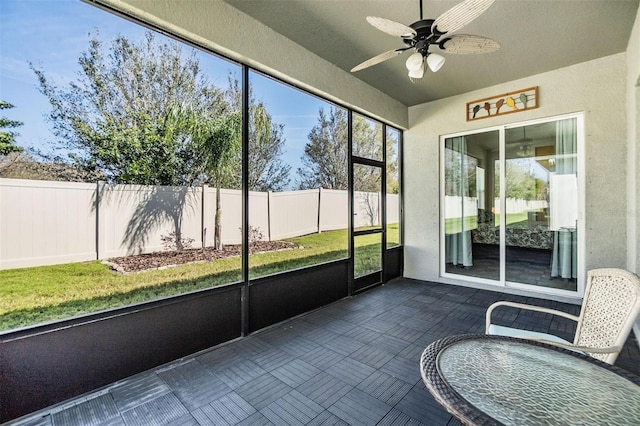 unfurnished sunroom featuring ceiling fan