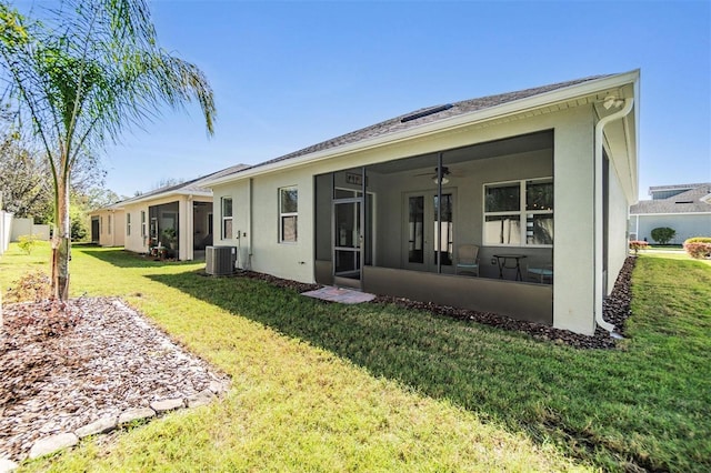 back of house with ceiling fan, central AC unit, a sunroom, a lawn, and stucco siding