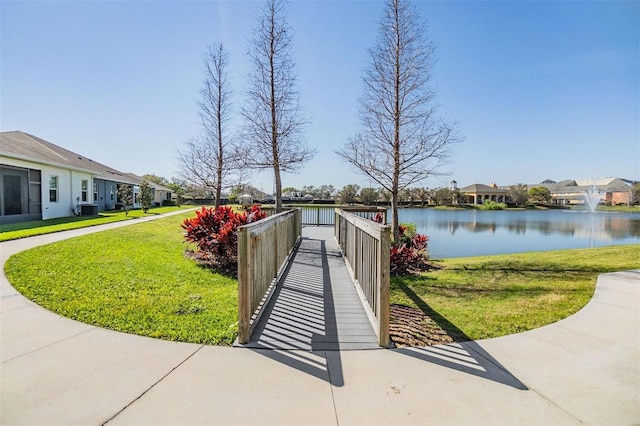 view of property's community featuring a residential view, a water view, and a lawn