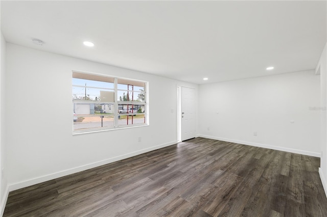 empty room with recessed lighting, dark wood finished floors, and baseboards