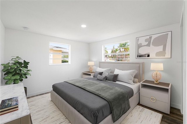 bedroom with recessed lighting, multiple windows, baseboards, and wood finished floors