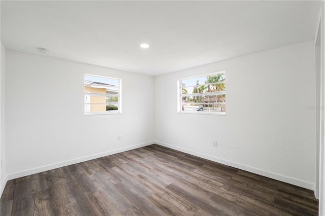 unfurnished room with dark wood-type flooring, recessed lighting, and baseboards