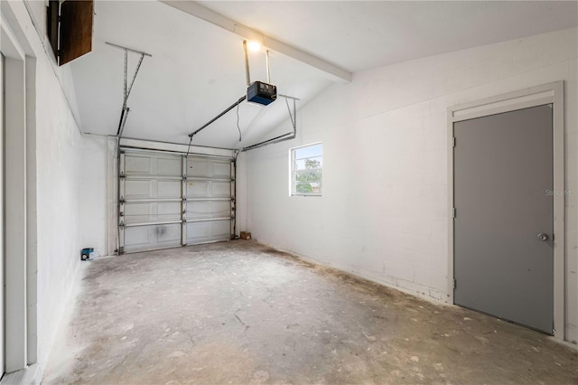 garage with a garage door opener and concrete block wall