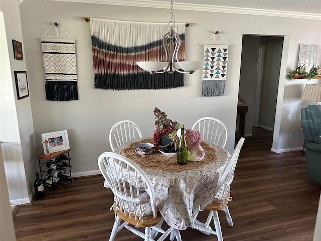 dining space featuring crown molding, baseboards, and wood finished floors