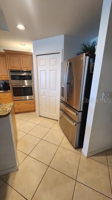 3805 Gulf Blvd Unit 404, St Pete Beach, FL 33706 - kitchen featuring stainless steel appliances, light tile patterned floors, dark stone counters, and recessed lighting