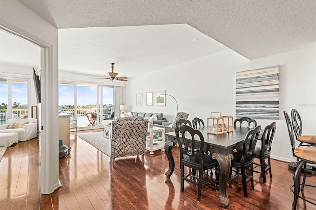 3805 Gulf Blvd Unit 404, St Pete Beach, FL 33706 - dining area with dark wood finished floors, a ceiling fan, and a textured ceiling