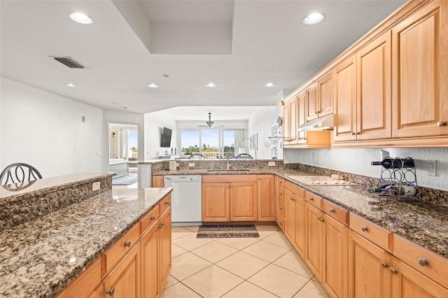 3805 Gulf Blvd Unit 404, St Pete Beach, FL 33706 - kitchen featuring white appliances, under cabinet range hood, dark stone counters, light tile patterned floors, and a peninsula