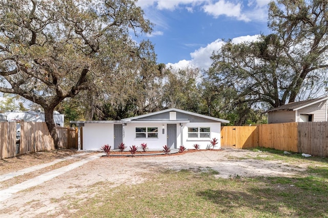 view of front facade featuring a gate, fence, and stucco siding