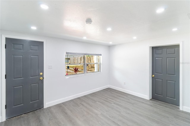 entrance foyer with recessed lighting, light wood-style flooring, and baseboards