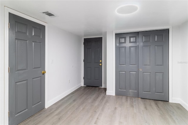 foyer with light wood finished floors, baseboards, and visible vents