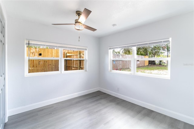 unfurnished room featuring ceiling fan, baseboards, and wood finished floors