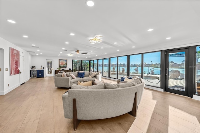 living area featuring light wood-type flooring, ceiling fan, baseboards, and recessed lighting