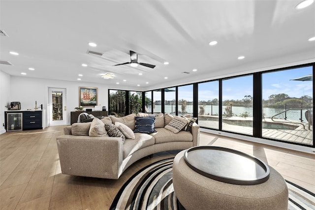 living room with a water view, light wood-style floors, visible vents, and recessed lighting