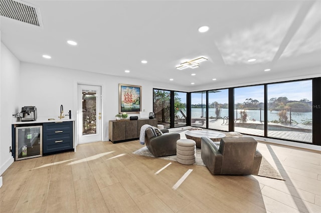 living room with a wealth of natural light, beverage cooler, visible vents, and recessed lighting