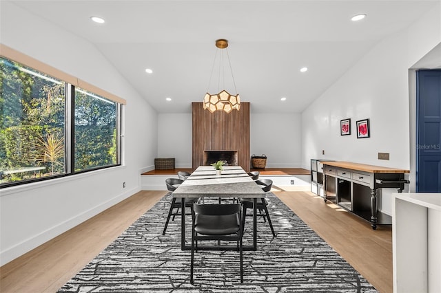 dining space with recessed lighting, vaulted ceiling, light wood-style flooring, and baseboards