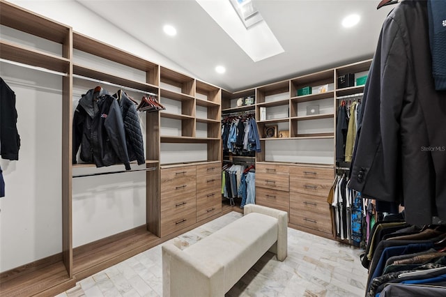 walk in closet featuring vaulted ceiling with skylight