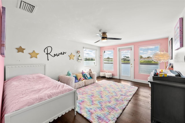 bedroom featuring wood finished floors, a ceiling fan, baseboards, visible vents, and access to exterior