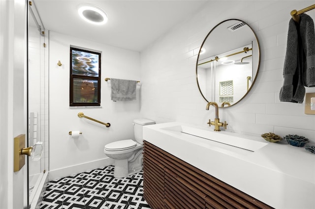 bathroom featuring visible vents, toilet, vanity, baseboards, and walk in shower