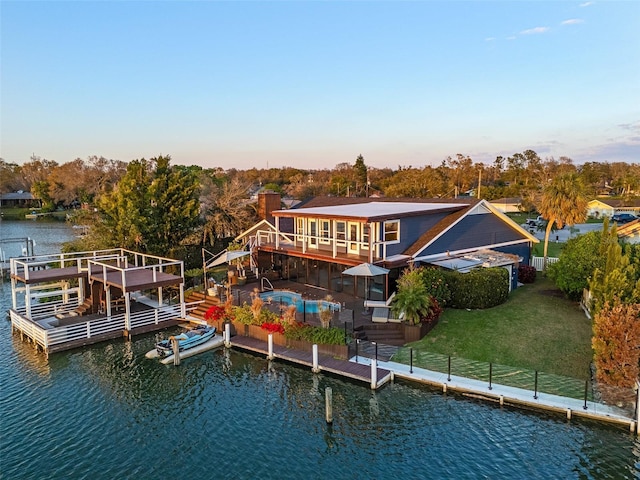 exterior space with a water view, a balcony, and a yard