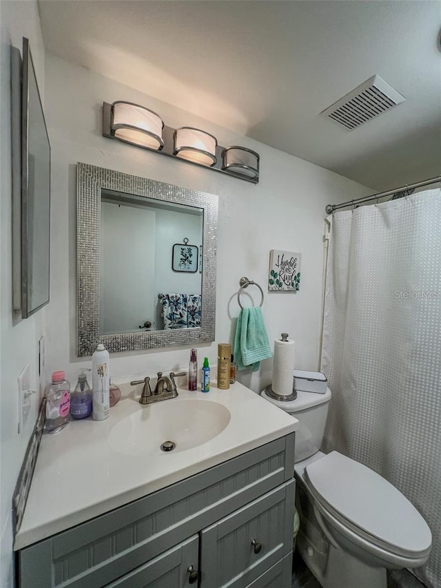 bathroom featuring visible vents, vanity, and toilet