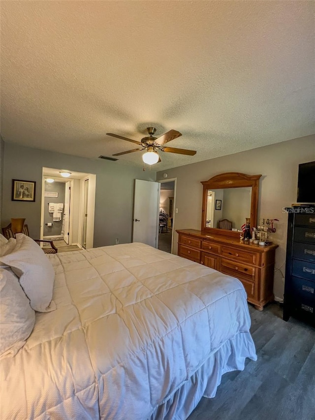 bedroom with ceiling fan, a textured ceiling, wood finished floors, and visible vents