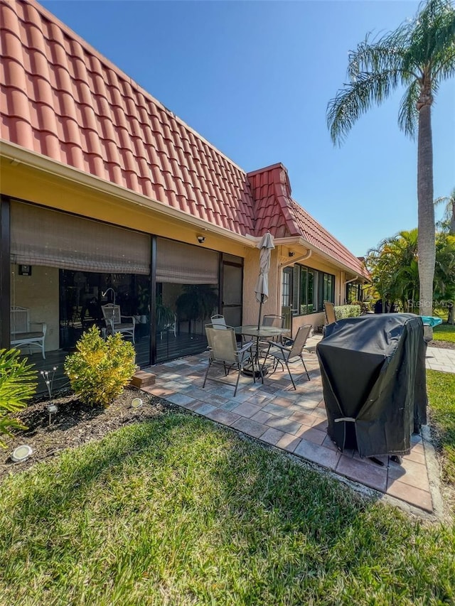 rear view of house with a patio area and a tile roof