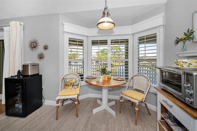 dining area with wine cooler, breakfast area, and baseboards