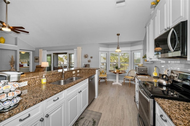 kitchen with stainless steel appliances, a healthy amount of sunlight, white cabinets, and a sink