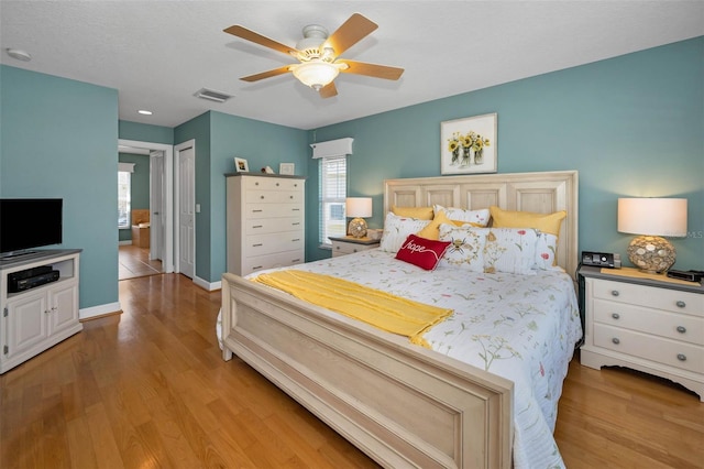 bedroom featuring a ceiling fan, baseboards, visible vents, light wood-style floors, and a closet