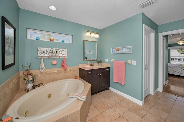 full bath featuring a textured ceiling, tile patterned flooring, vanity, visible vents, and a tub with jets