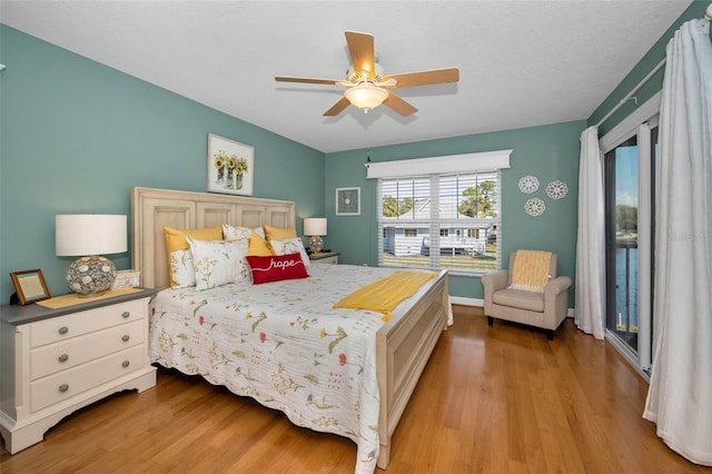 bedroom with access to exterior, a ceiling fan, and light wood-style floors