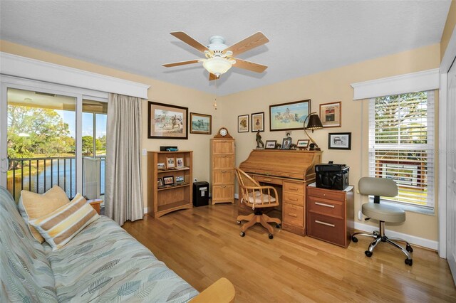 office with light wood-style floors, ceiling fan, and baseboards