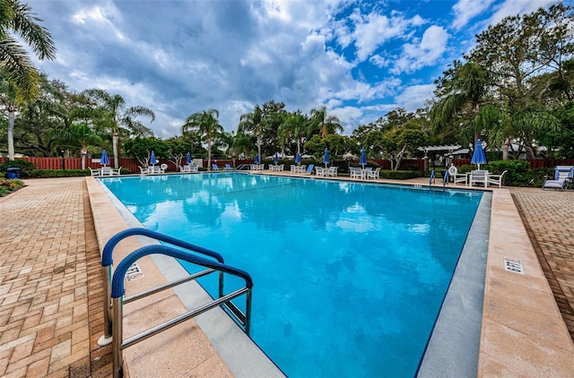 community pool featuring fence and a patio