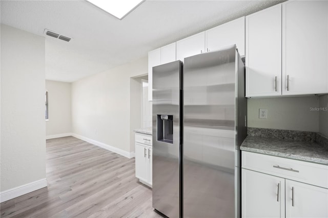 kitchen featuring white cabinets, light wood finished floors, visible vents, and stainless steel refrigerator with ice dispenser