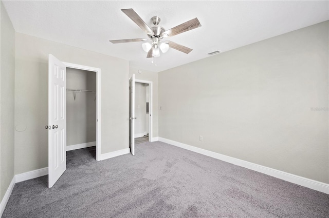 unfurnished bedroom featuring baseboards, visible vents, a ceiling fan, carpet, and a closet