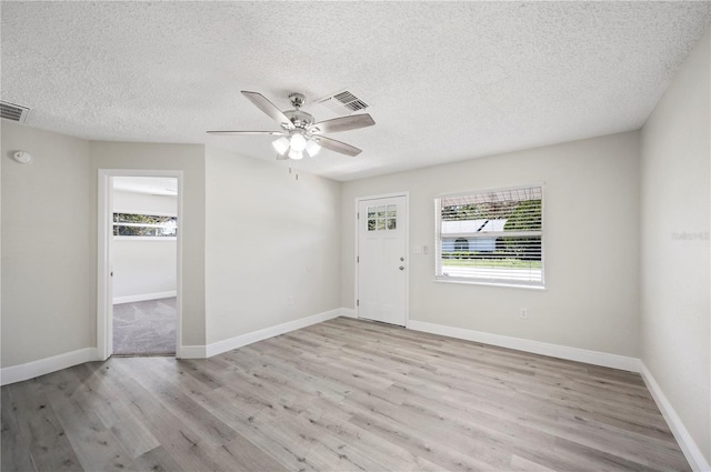 foyer entrance with light wood-type flooring, baseboards, visible vents, and ceiling fan