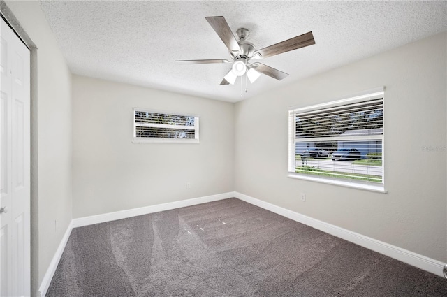 carpeted spare room with a textured ceiling, ceiling fan, and baseboards