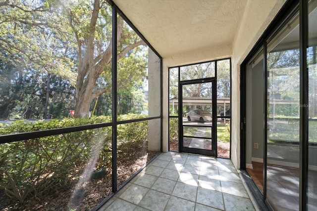 unfurnished sunroom with a healthy amount of sunlight and vaulted ceiling