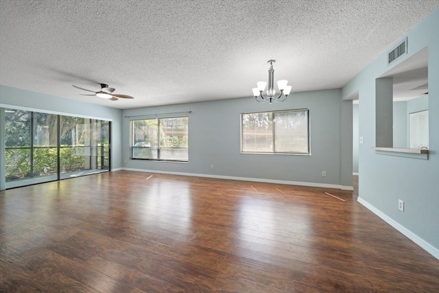 empty room with visible vents, wood-type flooring, baseboards, and ceiling fan with notable chandelier