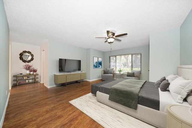 bedroom featuring baseboards, a textured ceiling, wood finished floors, and a ceiling fan