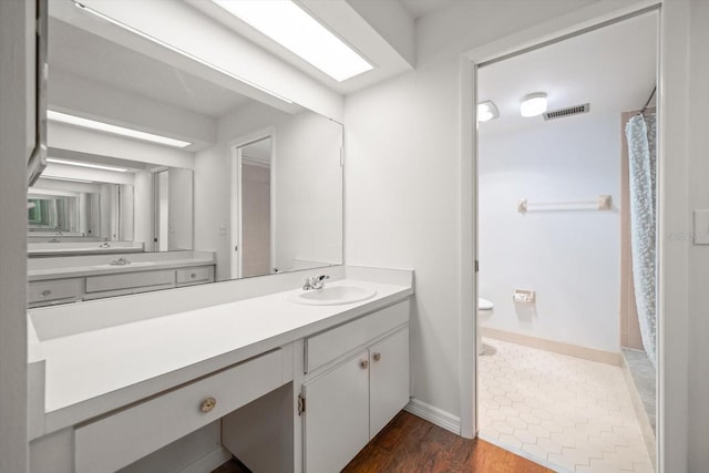 bathroom featuring visible vents, toilet, wood finished floors, a shower with shower curtain, and vanity