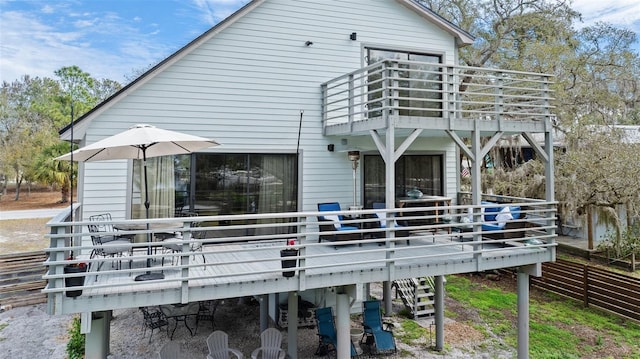 rear view of property featuring stairs, a deck, and a balcony